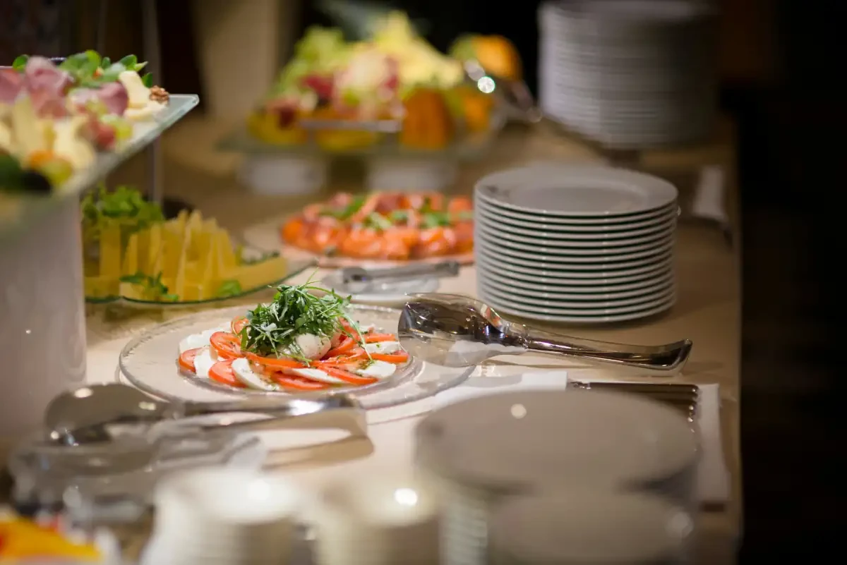 Caprese salad with fresh mozzarella, tomatoes, and arugula on a catering buffet.